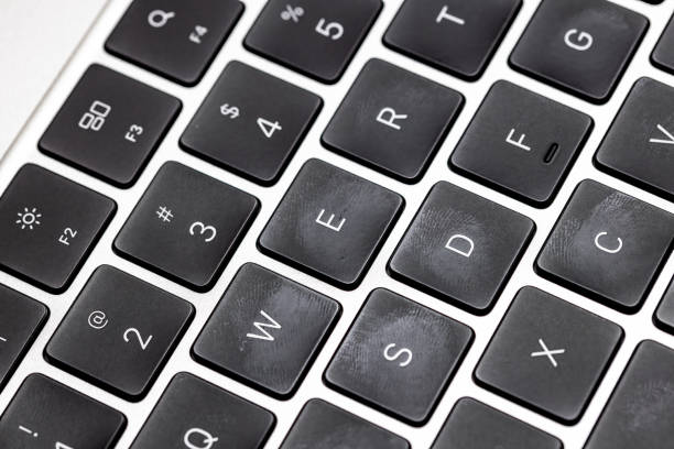 Computer keyboard keys that appear shiny and worn over time.