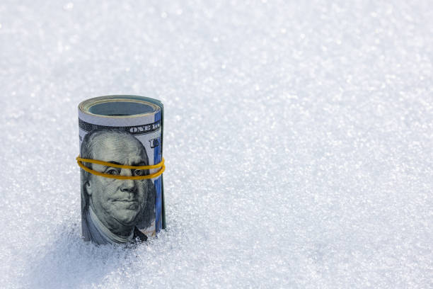 istock Roll of us dollar banknotes on the snow surface 2179528864