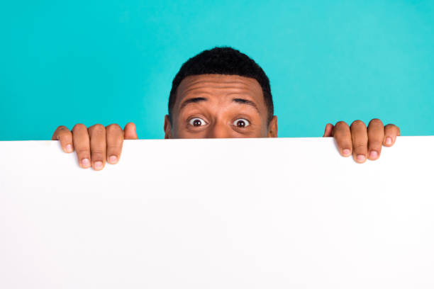 istock Portrait of nice young man hide peek behind empty space blank wear pullover isolated on turquoise color background 2179530441