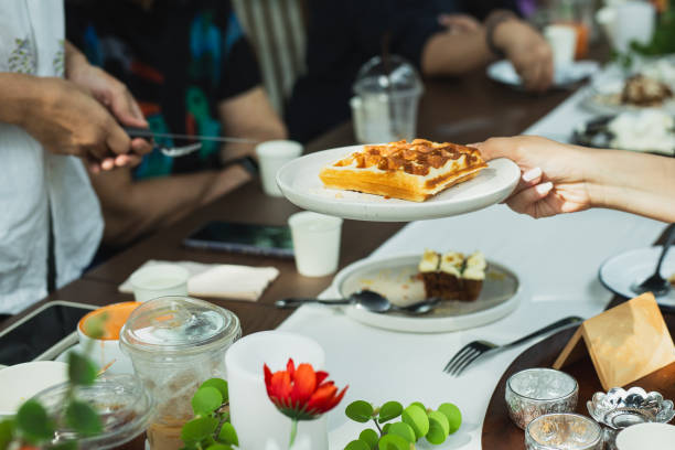 Waitress serving belgian waffles to customer in cafe