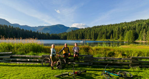 istock Family with mountain bikes pause by lakeshore 2179530892