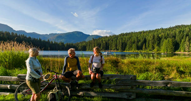 Family with mountain bikes pause by lakeshore