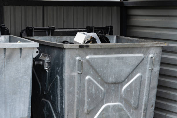 istock Two metallic garbage containers are positioned side by side, overflowing with various discarded items, captured during daylight in a city environment 2179532283