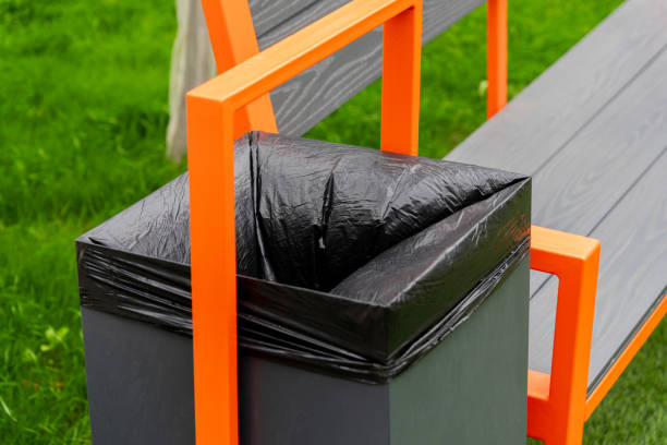 istock A black garbage container is attached to a park bench, showcasing a practical waste disposal solution in a well-kept grassy area, encouraging cleanliness in public spaces 2179532288