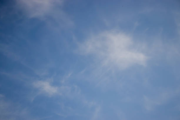 Blue sky with light clouds on a clear day. Perfect serene backdrop for nature or outdoor-themed content. Ideal for backgrounds or textures.