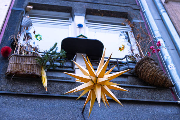 Holiday window decor with a bright star lantern, baskets, and winter accents, creating a rustic and cozy look. Handmade Christmas yellow star, created in Waldorf style.