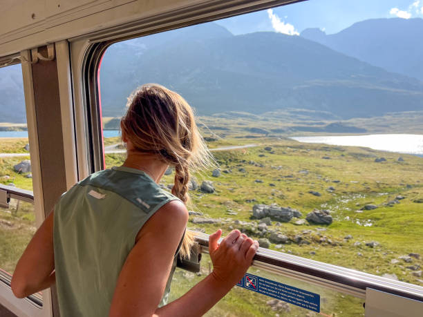 istock Woman Enjoying a Scenic Train Ride through Alpine Meadows 2179542738