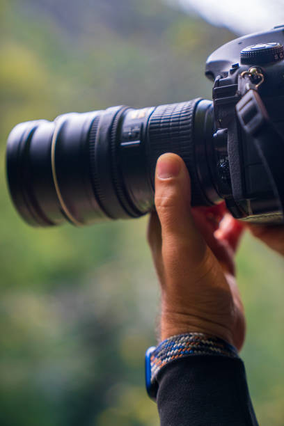 istock A person is holding a camera with a lens and a strap 2179547826