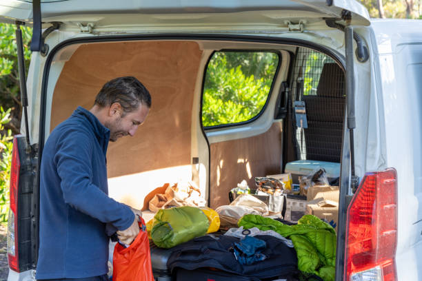 istock Man Organizing Camping Gear in Van 2179556500