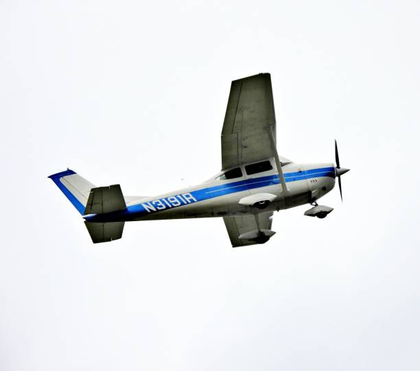 Cessna 172 Skyhawk flying with a blue sky behind it on a summer afternoon with its belly stained with oil