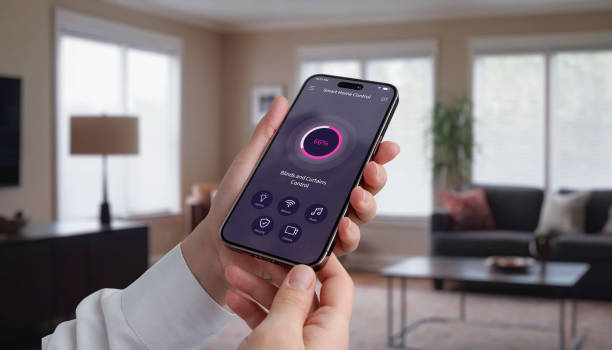 istock Controlling  blinds and curtains in the living room using a mobile app. Woman's hand with smartphone, modern home automation for light control and privacy 2179566314