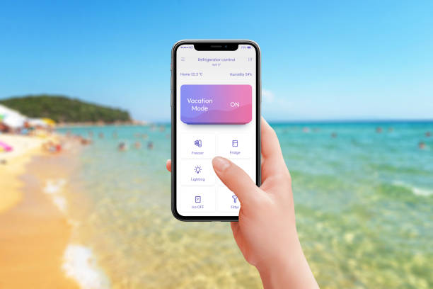 istock Controlling fridge and kitchen appliances from the beach with vacation mode activated. Mobile app in hand, enjoy smart home convenience while relaxing by the sea 2179566316