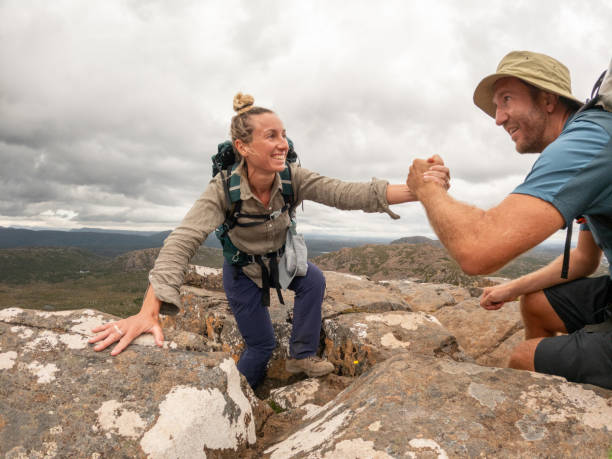 istock Couple Helping Each Other on Mountain Hike 2179569398