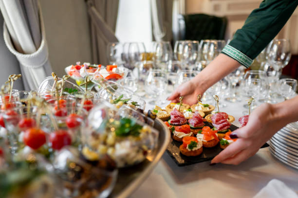 istock A variety of gourmet appetizers elegantly presented on a serving table, with a hand reaching for a dish. Perfect for culinary, catering, or event themes, showcasing the diversity of the food. 2179584171