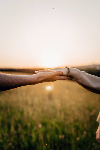istock Hands reaching out during sunset in a peaceful field 2179589612