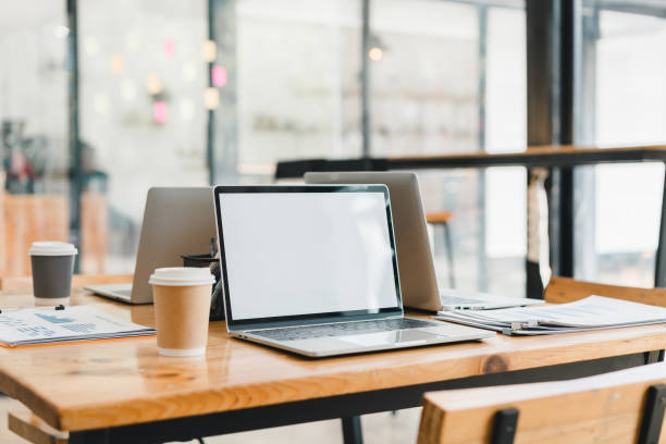 istock modern workspace featuring laptops, coffee cups, and documents on wooden table. clean and organized setup promotes productivity and creativity in contemporary office setting 2179591737