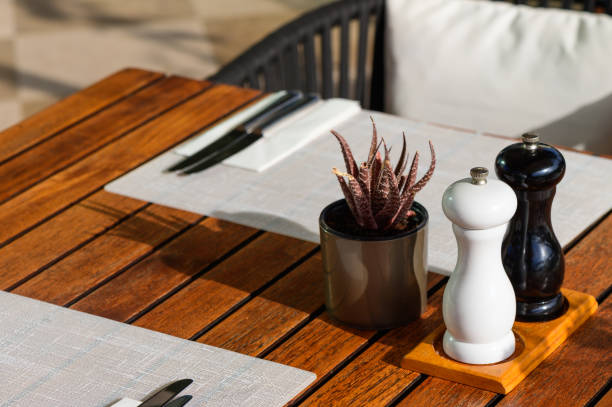 A beautifully arranged table setting with elegant utensils and a decorative plant in a serene outdoor dining atmosphere