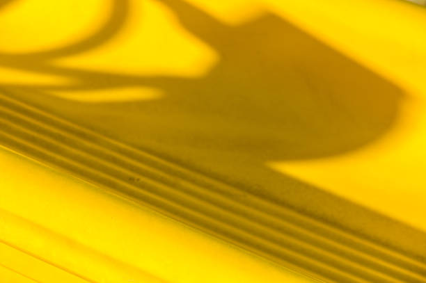 istock Shadows dance over vibrant yellow surface with intricate patterns captured in warm afternoon light 2179592962