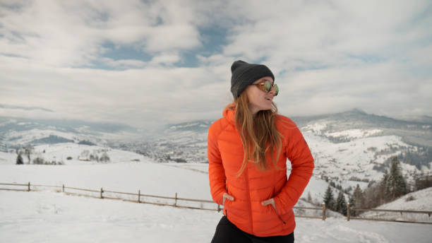 Young woman hikes through snow in winter, Carpathian Mountains