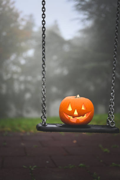 istock Carved pumpkin on swing 2179598877