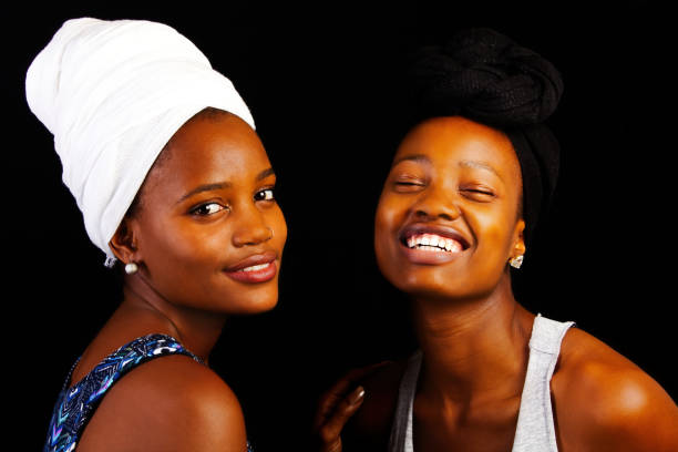 Two Attractive Young African American Sisters In Headscarfs On Black Background