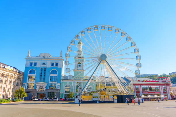 Kyiv, Ukraine - October 9, 2024: Vibrant view of Ferris wheel in Kontraktova Square with stunning architecture in background.