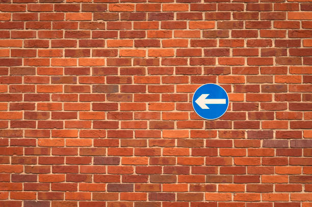 Brick Wall with Black and White One Way Sign