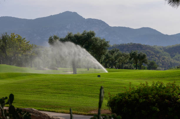 istock A tranquil early morning on a lush golf course with mist rising from sprinklers amid distant mountains 2179612086