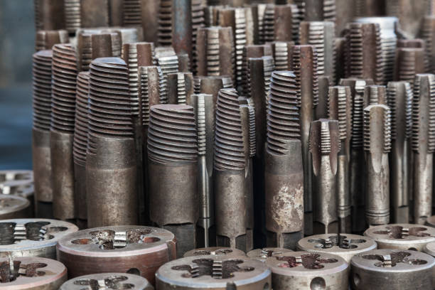Taps and dies for metal threading. Tools for cutting external and internal threads, close-up.Taps and dies for metal threading. Tools for cutting external and internal threads, close-up.