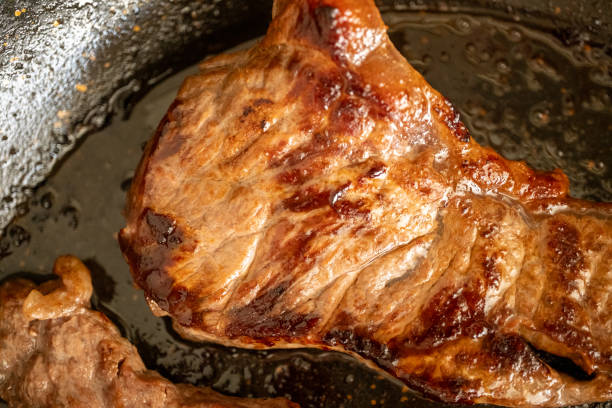 istock New York steak beef on black pan in close-up 2179614237