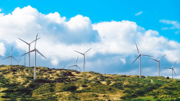 istock Wind turbines are situated on a grassy hill, with a large white cloud overhead. 2179615123