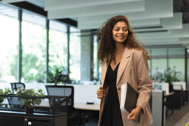 istock Businesswoman walking along the office corridor with documents. 2179621234