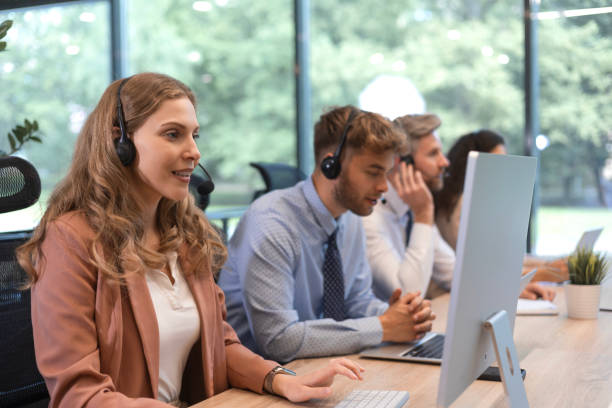 istock Portrait of call center worker accompanied by her team. Smiling customer support operator at work. 2179621572