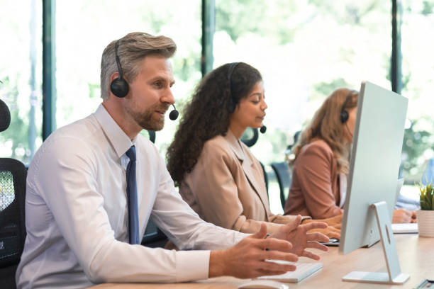 istock Portrait of call center worker accompanied by his team. Smiling customer support operator at work. 2179621766