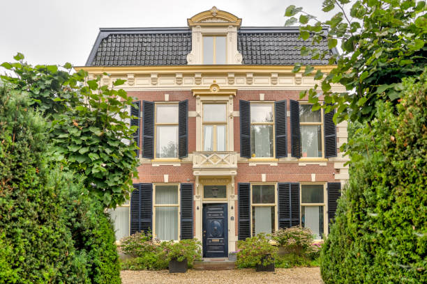Cute old Dutch house, low angle view with a big hedge on the left side, near the village Lisse.
