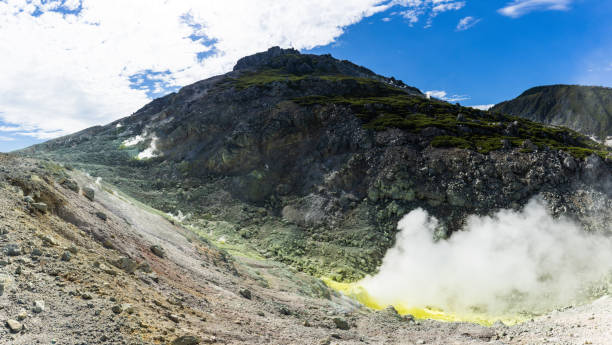 istock Heavy steam venting from volcanic mountain with yellow sulfur around base 2179632476