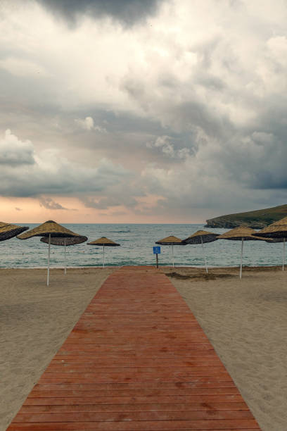 istock Relaxing Beach Scene with Bamboo Umbrellas and Path 2179636778