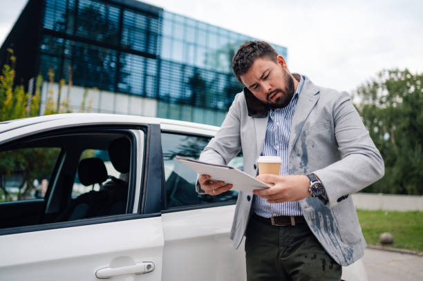 istock Stressed businessman talking on phone checking documents outside office 2179641412
