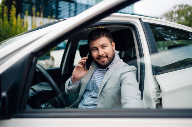 istock Businessman talking on the phone while sitting in car 2179641415