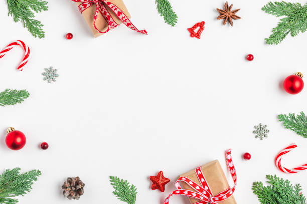 istock Christmas frame made of fir branches, gift boxes, red decorations, candy and pine cones on white background. Flat lay. Happy New Year and winter holidays background. Top view 2179642529