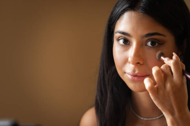 istock Young woman is blending liquid blush on her cheek. 2179642804