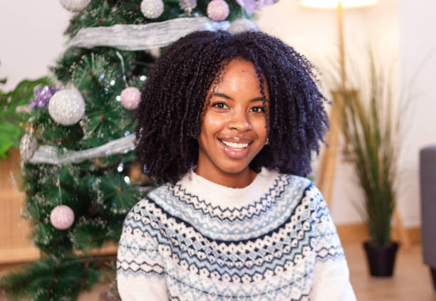 istock Beautiful woman smiling and posing next to christmas tree 2179645171