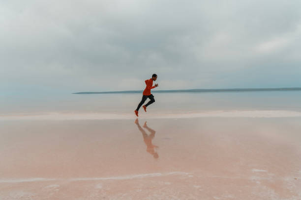 istock Man running on tropical beach at sunset 2179647645