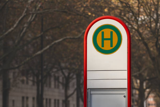 Picture of a bushaltestelle with its typical H sign in dortmund, indicating a bus stop nearby, typical from the German public transportation environment.The image captures a typical Haltestelle bus stop sign in Germany, characterized by its distinct yellow logo. The sign is prominently displayed, symbolizing public transportation in the country. The bus stop is part of a well-established public transport system in Germany, essential for daily commutes. This image can be used to highlight transportation infrastructure, German culture, or public signage.