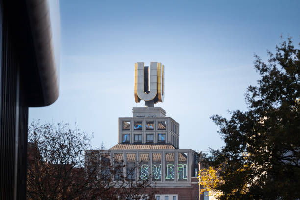 Dortmund, Germany - November 5, 2022: Picture of the main sign of the Dortmunder U. The U-Tower or Dortmunder U is a former brewery building in the city of Dortmund, Germany. Since 2010 it has served as a centre for the arts and creativity, housing among other facilities the Museum Ostwall. The Dortmunder U, an iconic landmark in Dortmund, Germany, under clear skies. This former brewery tower is a well-known symbol of industrial heritage and has been repurposed into a cultural center, housing art galleries and exhibitions. The golden 'U' atop the building represents a connection to the city's history and its transformation from an industrial hub to a center of culture. The structure stands tall in Dortmund's skyline, showcasing both its architectural and historical significance.
