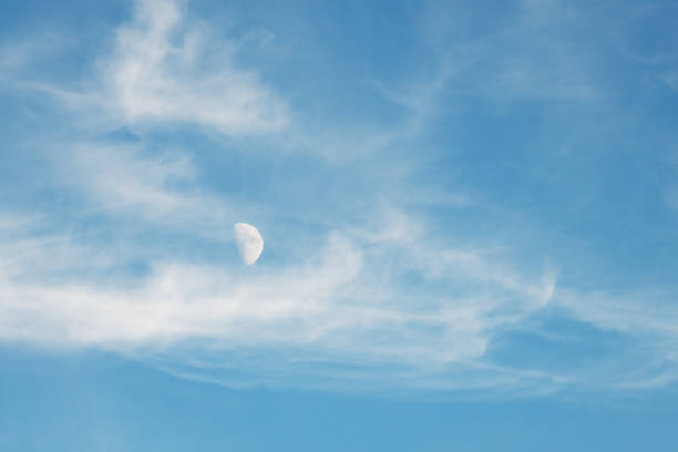 istock A first quarter moon apparently floats with the clouds in this daylight image 2179651760