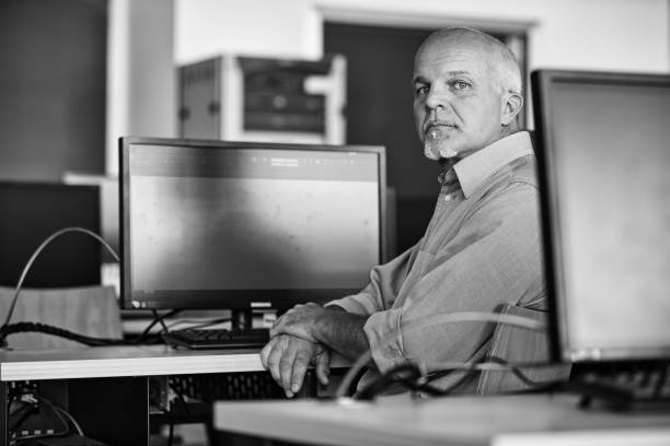istock Mature man sitting and working on computer in modern office 2179652032