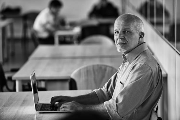 istock Senior it professional working on laptop in busy office 2179652082