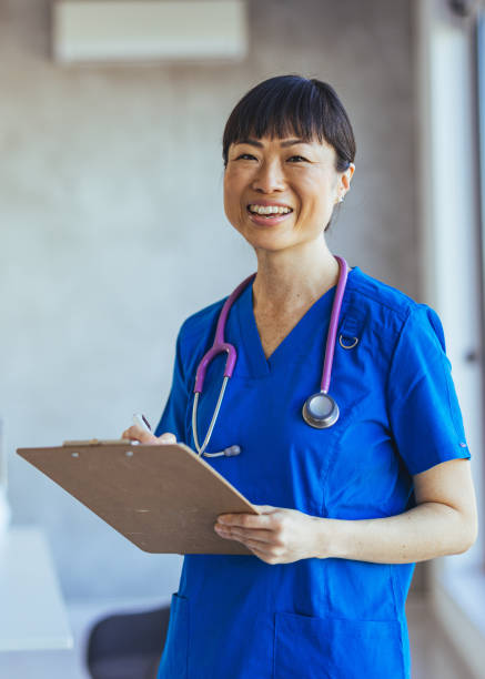 istock Smiling Nurse Holding Clipboard in Modern Hospital Environment 2179654603