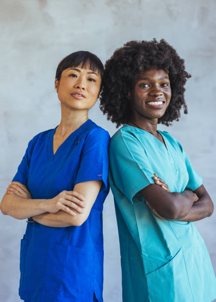 istock Confident Female Nurses Standing Back To Back in Scrubs Uniform 2179654711